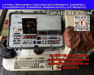 A space industry grade satellite controller from thirty years ago with a joystick and a 1990's Dell Desktop computer. The computer has a suspicious flap of red skin draped over it. THe caption reads "Our NEW/old satellite remote! complete with joysick! Worn and running Windows 2000 but we can work with it."
