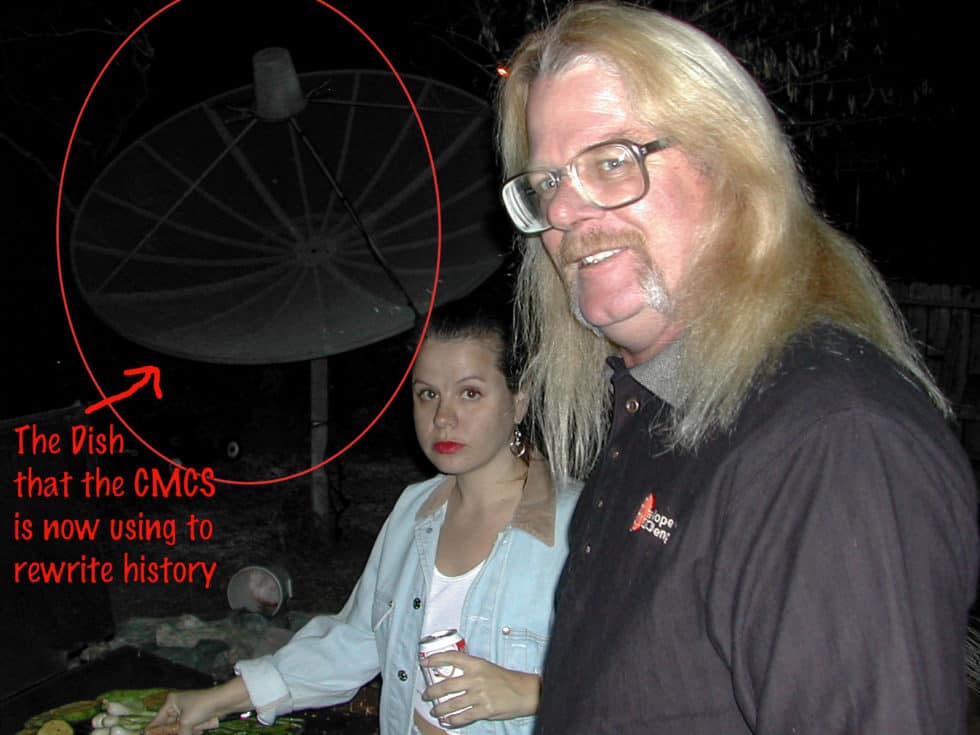 A bluff white man in his late forties with long blond hair, a handlebar mustache, and big square-rimmed glasses with a petite brunette woman holding a can of Budweiser and one hand and flipping onions on an outdoor grill with the other. Behind them the Spacerex satellite dish looms large. Caption:"The Dish that the CMCS is now using to rewrite history"